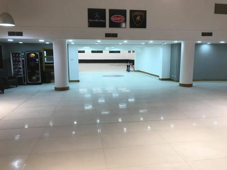 Commercial car showroom with a high-gloss large-format white porcelain floor