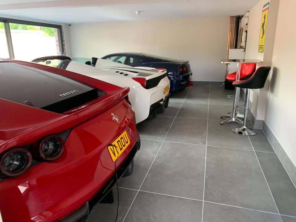 Interior of a private garage with grey porcelain floor tiles and matching tiled skirting
