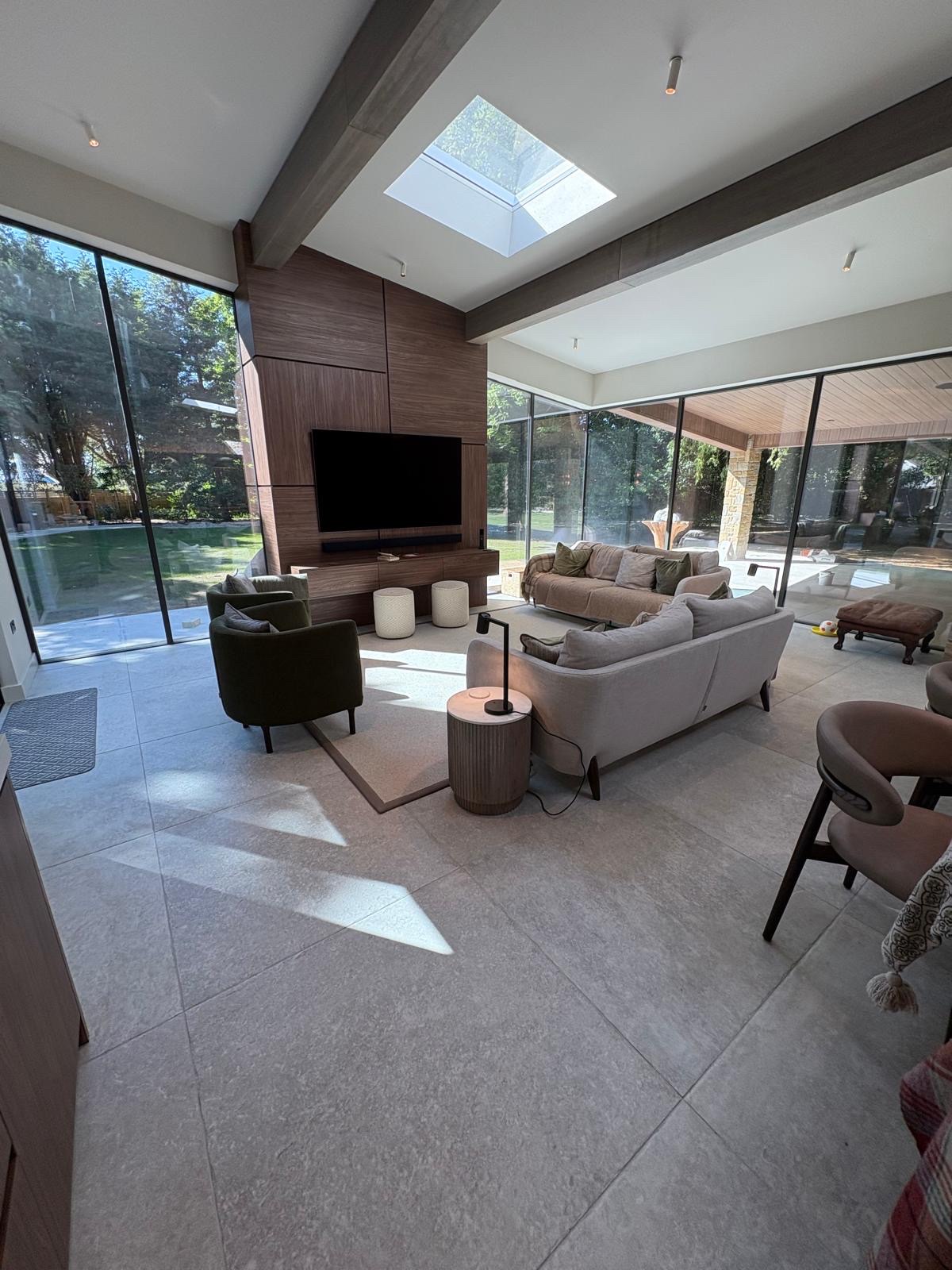 Bespoke walnut media wall with floating cabinetry in an open-plan living room